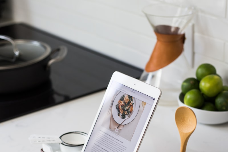 An open recipe book on a counter beside measured ingredients in small bowls.