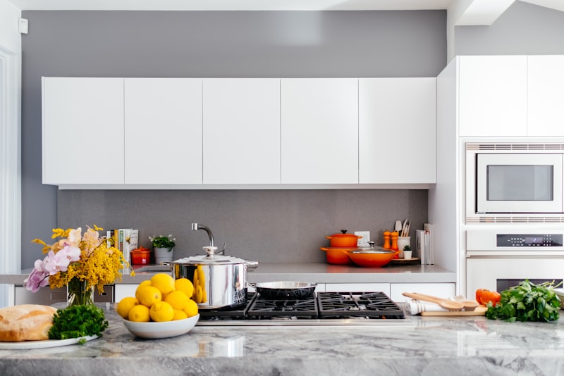 A compact, tidy kitchen with open shelving, hanging utensils, and a clear worktop.