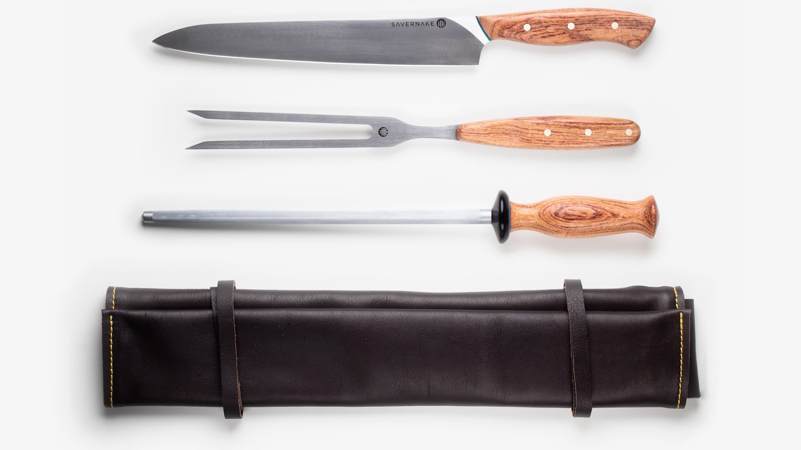 A chef's knife resting on a wooden cutting board beside freshly sliced vegetables.